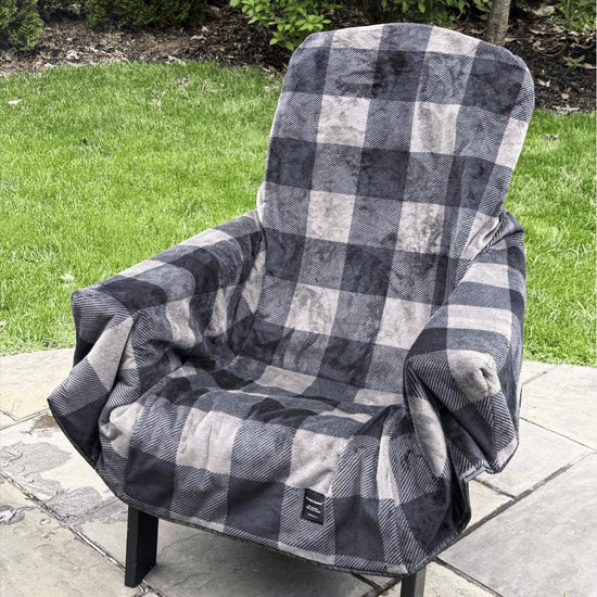 The Chair Blanket fleece chair cover on an outdoor chair, folding into its carry bag
