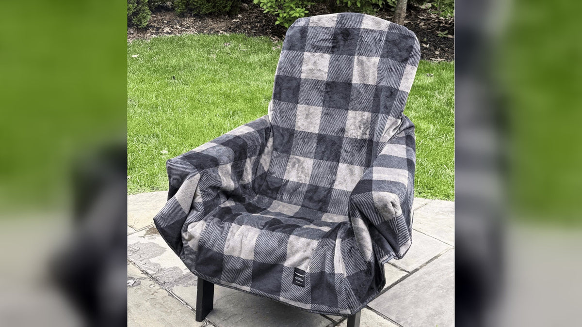 The Chair Blanket fleece chair cover on an outdoor chair, folding into its carry bag