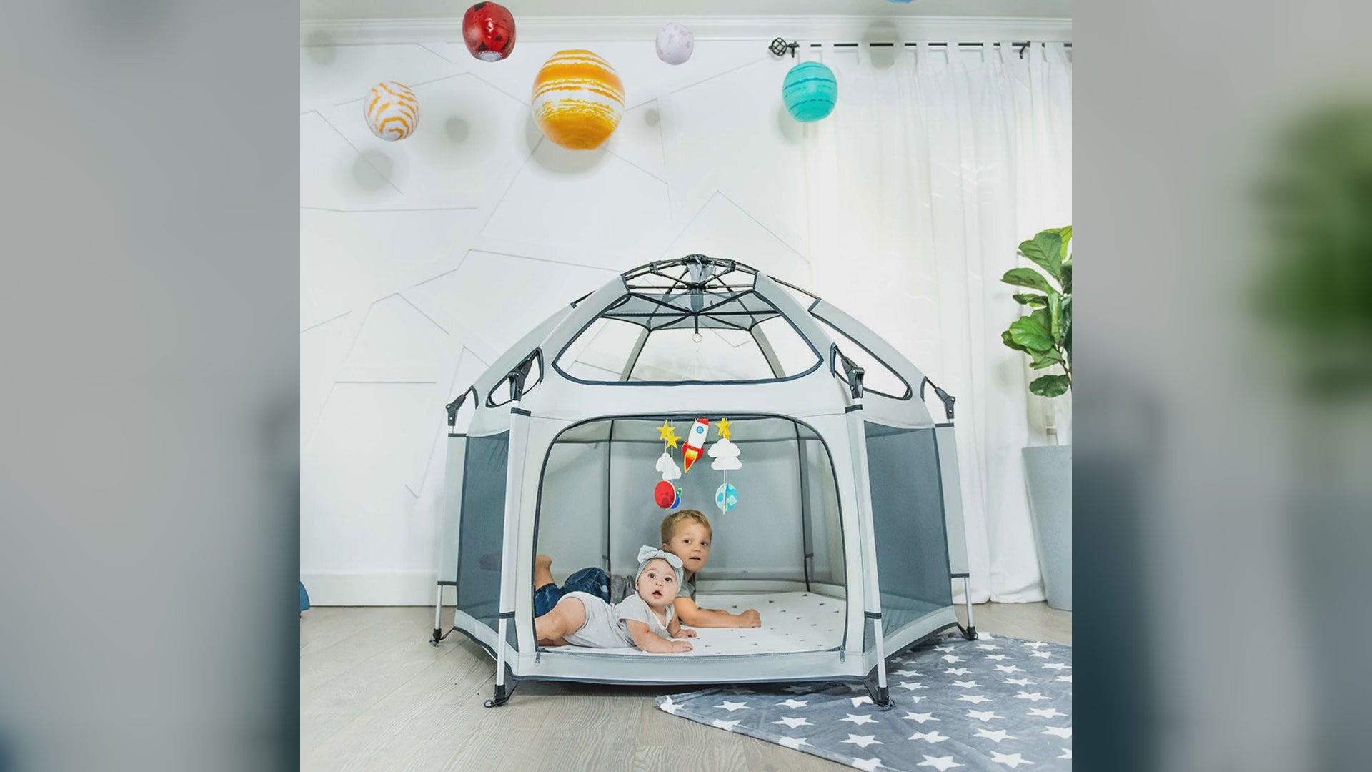 Kids playing inside a mint Pop N Go playpen at a park